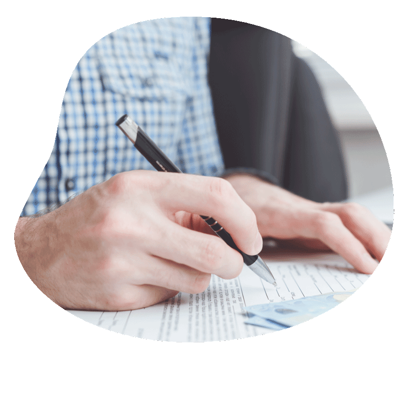 Person signing a document with a pen