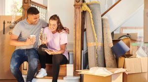 Couple taking a coffee break among moving boxes